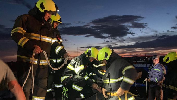 Olomoučtí hasiči při zásahu na jedné ze střech, kterou poničila středeční bouřka.