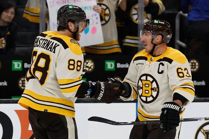 David Pastrňák slaví vítězství nad Chicagem s kapitánem Bostonu Bradem Marchandem