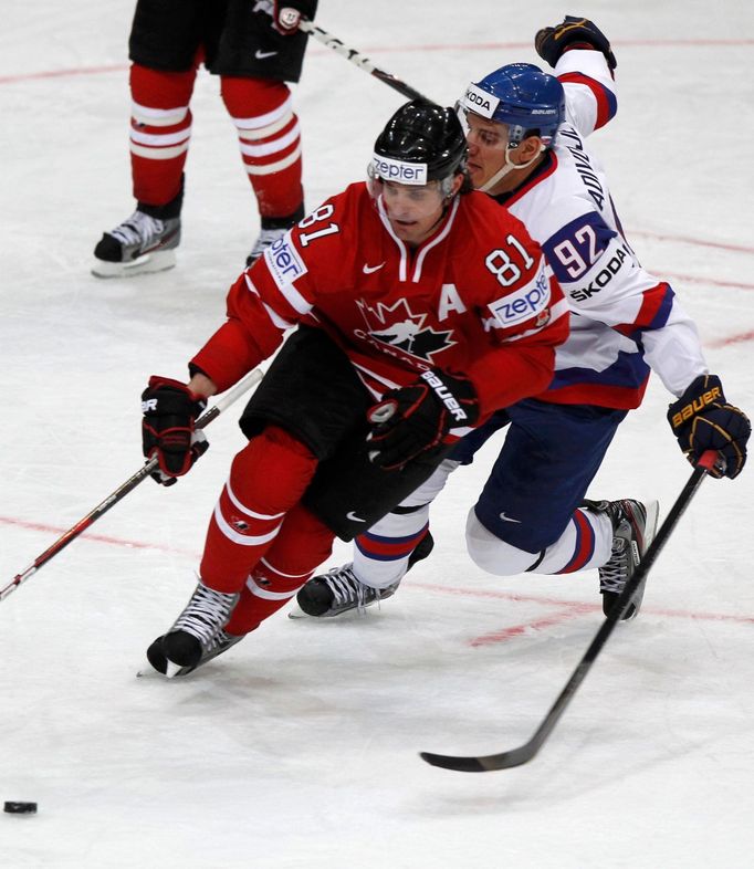 Branko Radivojevič a Patrick Sharp bojují o puk v utkání MS v hokeji 2012 Kanada - Slovensko.