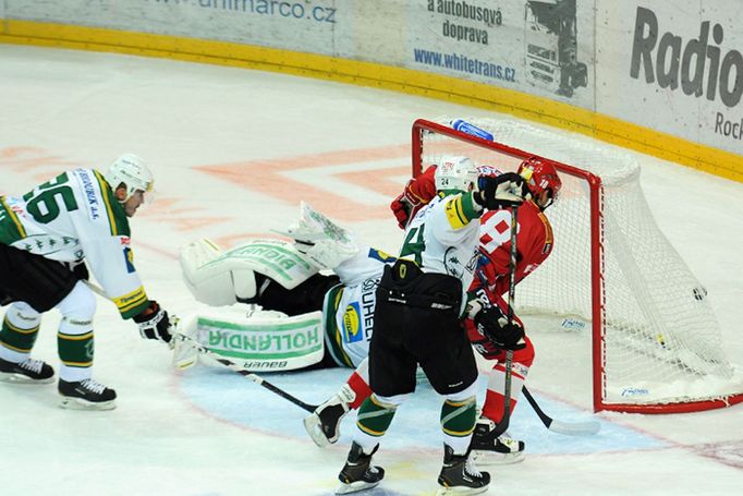 Hokejista Slavie Praha Jaroslav Kalla střílí gól za záda Lukáše Mensatora a před Jan Košťálem (vlevo) v utkání 5. kola Tipsport extraligy 2012/13 s Karlovými Vary.