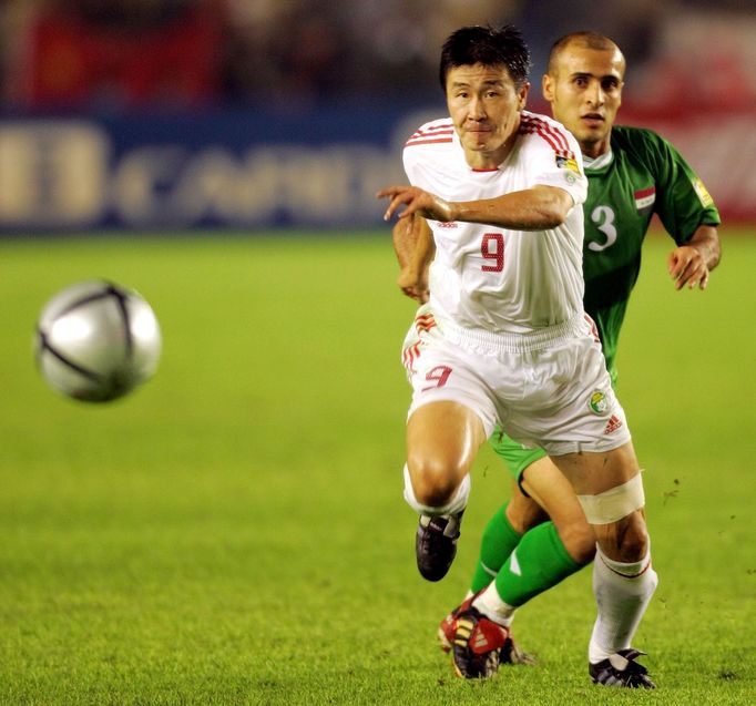 FILE PHOTO: China's striker Hao haidong (white jersey) and Iraq's Basim Abbas chase a loose ball during a quarterfinal match at the Asian Cup Soccer in Beijing July 30, 2