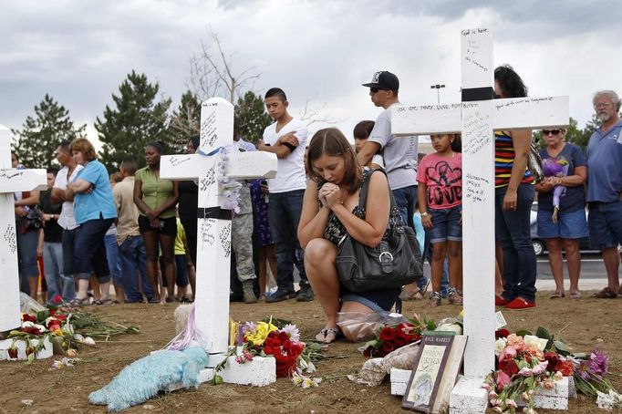 A woman prays at a memorial for victims behind the theater where a gunman opened fire on moviegoers in Aurora, Colorado July 22, 2012. President Barack Obama travels to Colorado on Sunday to meet families bereaved after a "demonic" gunman went on a shooting rampage at a movie theater in a Denver suburb, killing at least 12 people and wounding 58. REUTERS/Shannon Stapleton (UNITED STATES - Tags: DISASTER SOCIETY CIVIL UNREST) Published: Čec. 22, 2012, 10:50 odp.