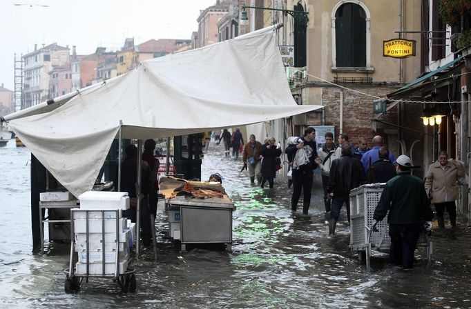 A worker transports materials during a period of seasonal high water in Venice October 27, 2012. The water level in the canal city rose to 127 cm (50 inches) above the normal level, according to the monitoring institute. REUTERS/Manuel Silvestri (ITALY - Tags: ENVIRONMENT SOCIETY TRAVEL) Published: Říj. 27, 2012, 12:23 odp.