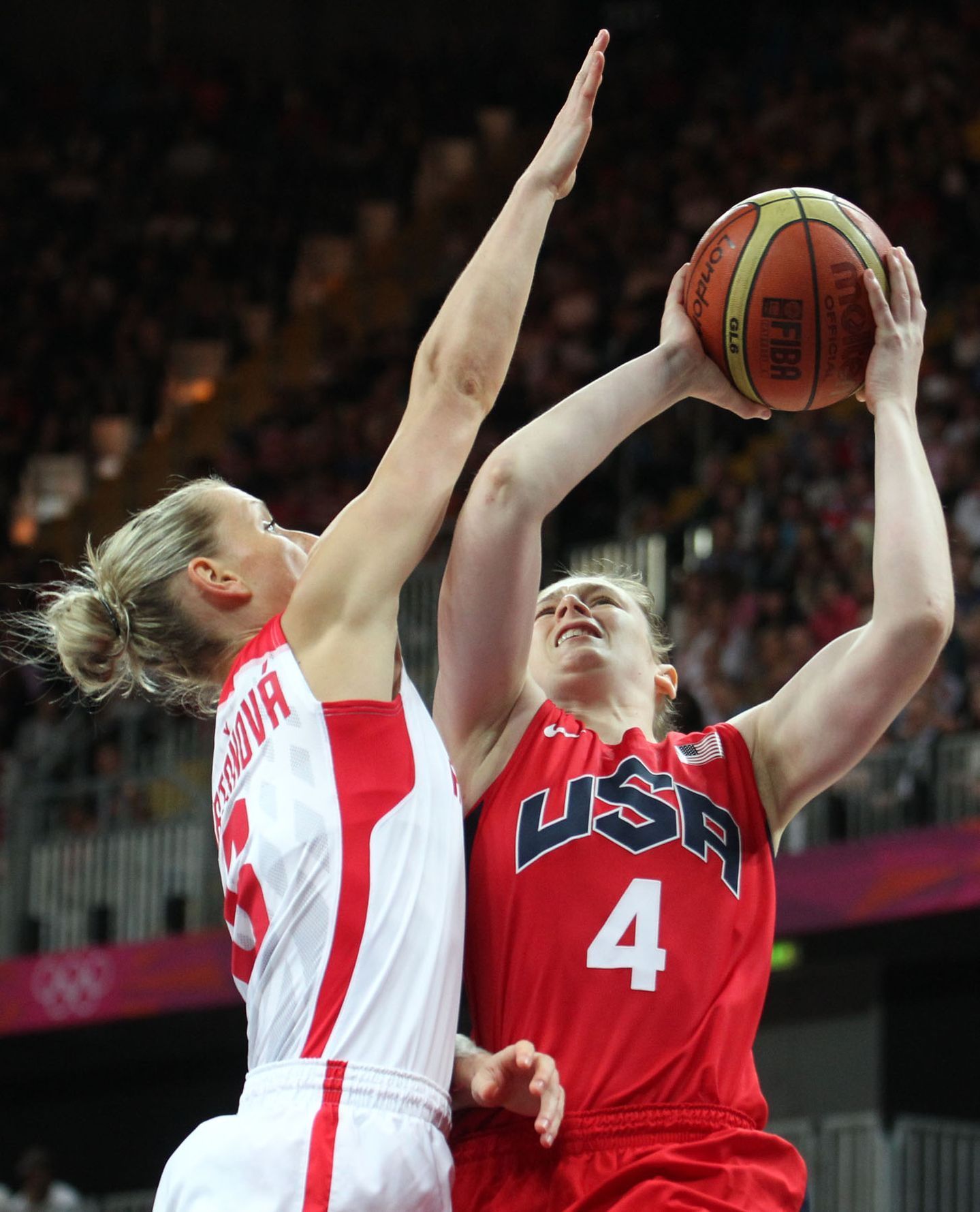 Česká basketbalistka Kateřina Bartoňová brání Američanku Lindsay Whalenovou v utkání skupiny A na OH 2012 v Londýně.