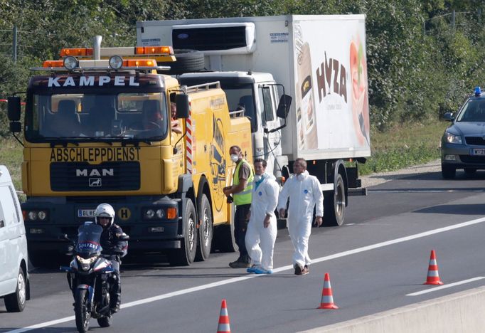 Forenzní experti zkoumají odstavený vůz na dálnici A4, v němž byly nalezeny ostatky desítek uprchlíků.