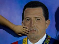 Chlapec ukazuje na kresbu Huga Cháveze v Caracasu.