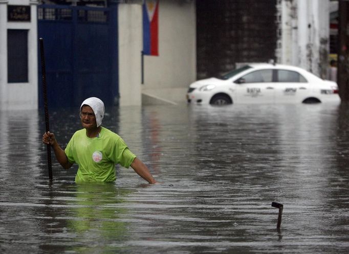 PHILIPPINES/ Description: A road emergency crew member wades through waist-deep floodwater to unclog drains after a heavy downpour in Quezon City, Metro Manila July 3, 2012. Heavy rain has flooded some roads, causing classes to be suspended in parts of Metro Manila, local media reported. REUTERS/Cheryl Ravelo (PHILIPPINES - Tags: ENVIRONMENT) Published: Čec. 3, 2012, 1:53 dop.