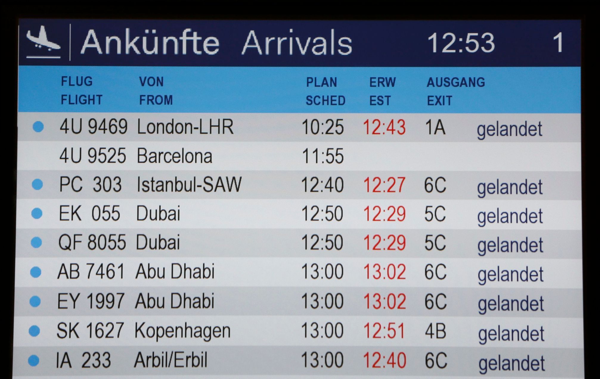 Příletová informační tabule na letišti v Düsseldorfu. Let z Barcelony je druhý odshora.
