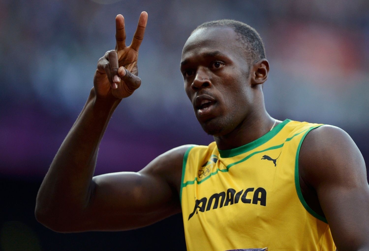 Jamajský sprinter Usain Bolt zdraví fanoušky během semifinále na 100 metrů na OH 2012 v Londýně.