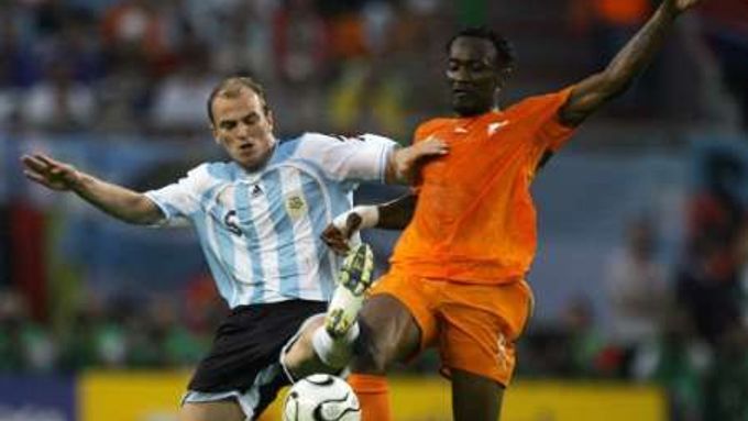 Argentinec Esteban Cambiasso (vlevo) a Didier Zokora z Pobřeží Slonoviny bojují o míč.