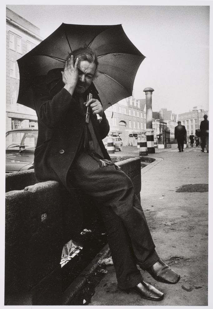 Markéta Luskačová: Man playing mouthorgan in front of Christ Church, Commercial Road, London, 1978