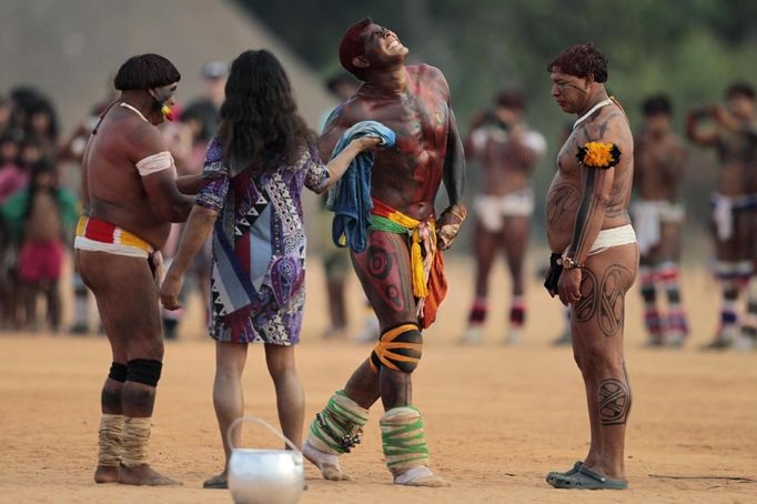 A Yawalapiti man reacts in pain after losing a wrestling match as part of this year's 'quarup,' a ritual held over several days to honour in death a person of great importance to them, in the Xingu National Park, Mato Grosso State, August 19, 2012. This year the Yawalapiti tribe honoured two people - a Yawalapiti Indian who they consider a great leader, and Darcy Ribeiro, a well-known author, anthropologist and politician known for focusing on the relationship between native peoples and education in Brazil. Picture taken August 19, 2012. REUTERS/Ueslei Marcelino (BRAZIL - Tags: SOCIETY ENVIRONMENT) FOR EDITORIAL USE ONLY. NOT FOR SALE FOR MARKETING OR ADVERTISING CAMPAIGNS. ATTENTION EDITORS - PICTURE 17 OF 37 FOR THE PACKAGE 'THE YAWALAPITI QUARUP RITUAL' Published: Srp. 29, 2012, 10:21 dop.