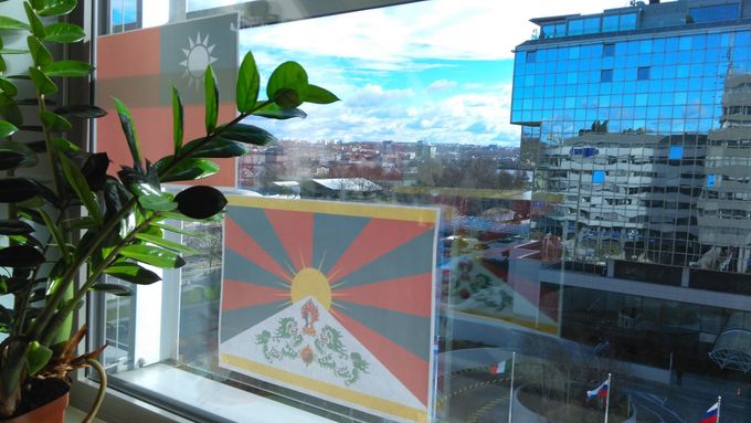 Tibetská vlajka vyvěšená v okně naproti hotelu Hilton.