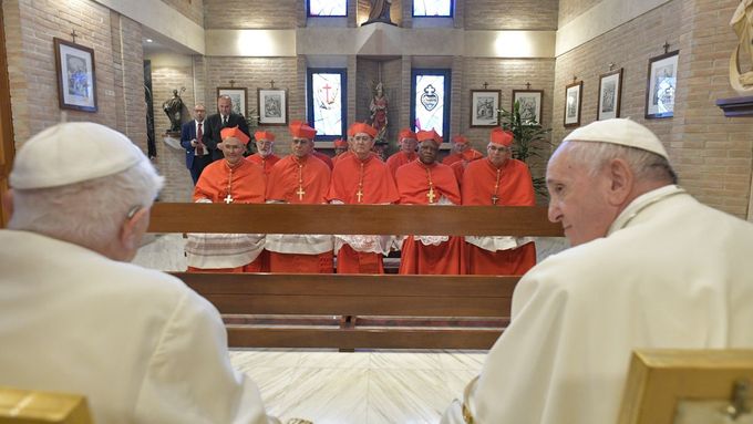 Hrdinovi knihy se zjevují papežové a s oblibou ho popichují. Na ilustračním snímku jsou současný papež František a jeho předchůdce Benedikt XVI.