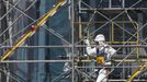 A worker wearing protective suit and mask climbs a scaffolding of the construction site of the multi-nuclide removal facility at Tokyo Electric Power Co. (TEPCO)'s tsunami-crippled Fukushima Daiichi nuclear power plant in Fukushima prefecture, March 6, 2013, ahead of the second-year of anniversary of the the March 11, 2011 tsunami and earthquake. REUTERS/Issei Kato (JAPAN - Tags: DISASTER ANNIVERSARY BUSINESS CONSTRUCTION ENERGY) Published: Bře. 6, 2013, 10:54 dop.