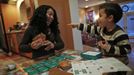 Mercedes Santos shares a laugh with her son Jaidon while playing cards at their home in Chicago, Illinois, December 22, 2012. Santos and her partner Theresa Volpe are a same-sex couple raising two of their biological children as they struggle to get same-sex marriages passed into law in Illinois. Picture taken December 22, 2012. REUTERS/Jim Young (UNITED STATES - Tags: SOCIETY) Published: Bře. 25, 2013, 6:07 odp.