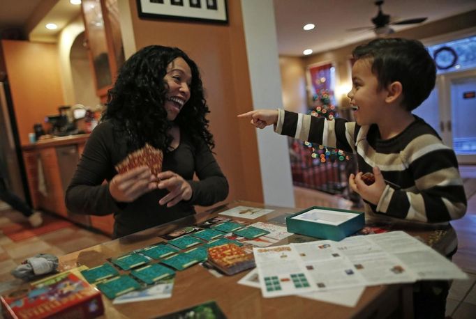 Mercedes Santos shares a laugh with her son Jaidon while playing cards at their home in Chicago, Illinois, December 22, 2012. Santos and her partner Theresa Volpe are a same-sex couple raising two of their biological children as they struggle to get same-sex marriages passed into law in Illinois. Picture taken December 22, 2012. REUTERS/Jim Young (UNITED STATES - Tags: SOCIETY) Published: Bře. 25, 2013, 6:07 odp.