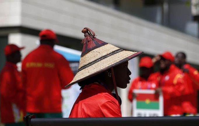 Marthe Koala, a runner from Burkina Faso, wears a traditional hat while she and other team members gather for the Olympic Team Welcome Ceremony at the Athletes' Village at the Olympic Park in London, July 22, 2012. Opening ceremonies for the London 2012 Olympics will be held on Friday. REUTERS/Jae C. Hong/Pool (BRITAIN - Tags: SPORT OLYMPICS SPORT ATHLETICS) Published: Čec. 22, 2012, 4:03 odp.