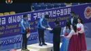 South Korean weightlifters Lee Young-gyun (L) stands as Kim Woo-sik (C) receives his award on the podium during their medal ceremony as part of the Asian Cup and Interclu