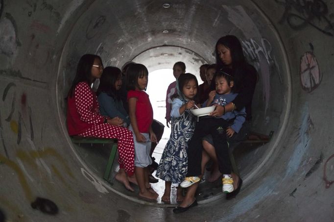 Israelis sit inside a sewage pipe used as shelter during an alert, warning of incoming rockets, in the southern community of Nitzan, near Ashdod November 15, 2012. A Hamas rocket killed three Israelis north of the Gaza Strip on Thursday, drawing the first blood from Israel as the Palestinian death toll rose to 15 in a military showdown lurching closer to all-out war and an invasion of the enclave. REUTERS/Nir Elias (ISRAEL - Tags: POLITICS CIVIL UNREST) Published: Lis. 15, 2012, 4:42 odp.