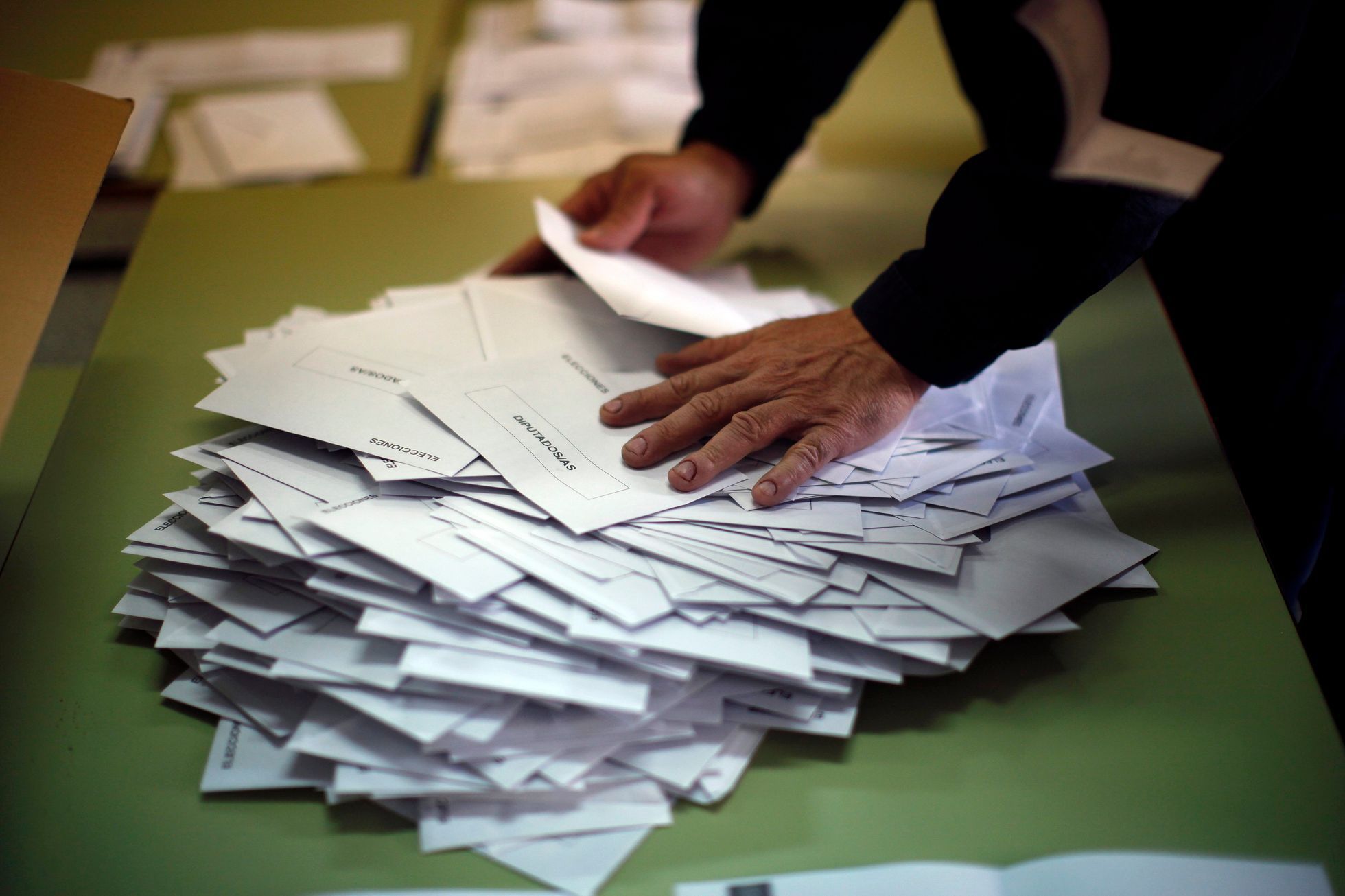 A man, member of an electoral table, counts the ballots after the European Parliament elections at a polling station in Ronda