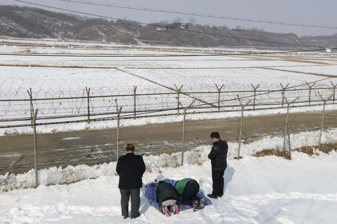 A man (L), who was originally from North Korea, and his South Korean family members bow in the direction of the North during a memorial service for their North Korean ancestors near the demilitarized zone separating the two Koreas, in Paju, 55 km (34 miles) north of Seoul February 10, 2013, on the occasion of Seolnal, the Korean Lunar New Year's day. Millions of South Koreans travelled to their hometowns during the three-day holiday which started last Saturday. Seolnal is one of the traditional holidays when most Koreans visit their hometowns to be united with their families and hold memorial services for their deceased ancestors. REUTERS/Lee Jae-Won (SOUTH KOREA - Tags: MILITARY POLITICS SOCIETY) Published: Úno. 10, 2013, 6:14 dop.