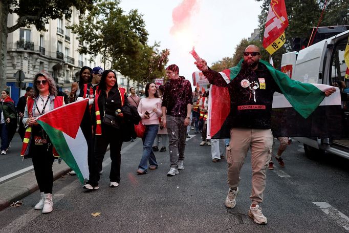 Demonstranti v vestách odborové organizace CGT drží palestinské vlajky během demonstrace v Paříži v rámci celonárodní stávky a protestů proti vládě.
