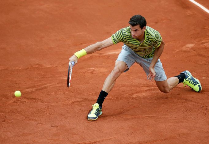 Grigor Dimitrov of Bulgaria returns a backhand to Ivo Karlovic of Croatia during their men's singles match at the French Open tennis tournament at the Roland Garros stadi