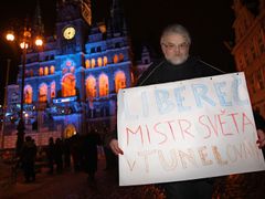 Jaroslav Schnirch s transparentem před nasvícenou libereckou radnicí.
