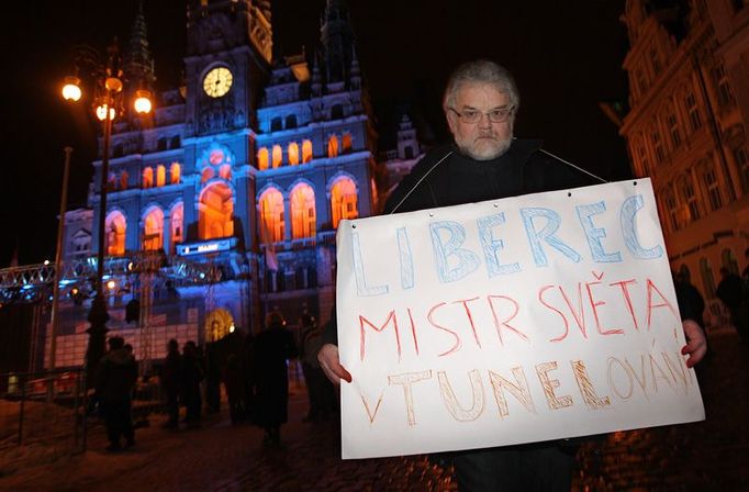 Jaroslav Schnirch s transparentem před nasvícenou libereckou radnicí.