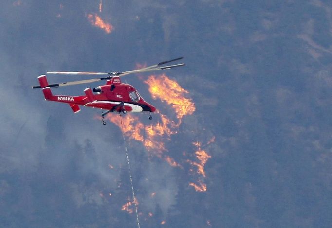 A firefighting helicopter approaches the Waldo Canyon fire west of Colorado Springs in Colorado June 26, 2012. A monster Colorado wildfire raging near some of the most visited tourist areas in the state took a turn for the worse on Tuesday as hot winds pushed flames north, prompting the evacuation of 7,000 more people, officials said. REUTERS/Rick Wilking (UNITED STATES - Tags: DISASTER ENVIRONMENT) Published: Čer. 27, 2012, 1:01 dop.