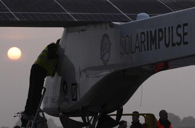 A crew member prepares the Solar Impulse aircraft before take off at Payerne airport May 24, 2012. The Solar Impulse HB-SIA prototype aircraft, which has 12,000 solar cells built into its 64.3 metres (193 feet) wings, attempted its first intercontinental flight from Payerne to Rabat in Morocco with a few days for a technical stop and a change of pilot in Madrid. This flight will act as a final rehearsal for the 2014 round-the-world flight. REUTERS/Denis Balibouse (SWITZERLAND - Tags: TRANSPORT SCIENCE TECHNOLOGY SOCIETY) Published: Kvě. 24, 2012, 8:11 dop.