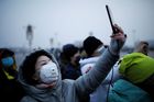 Žena s maskou na náměstí Tiananmen