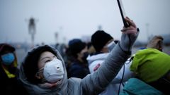 Žena s maskou na náměstí Tiananmen