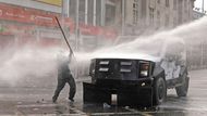 Santiago, Chile: demonstrant je zasažen proudem vody z vodního děla během násilností při prvomájovém shromáždění.