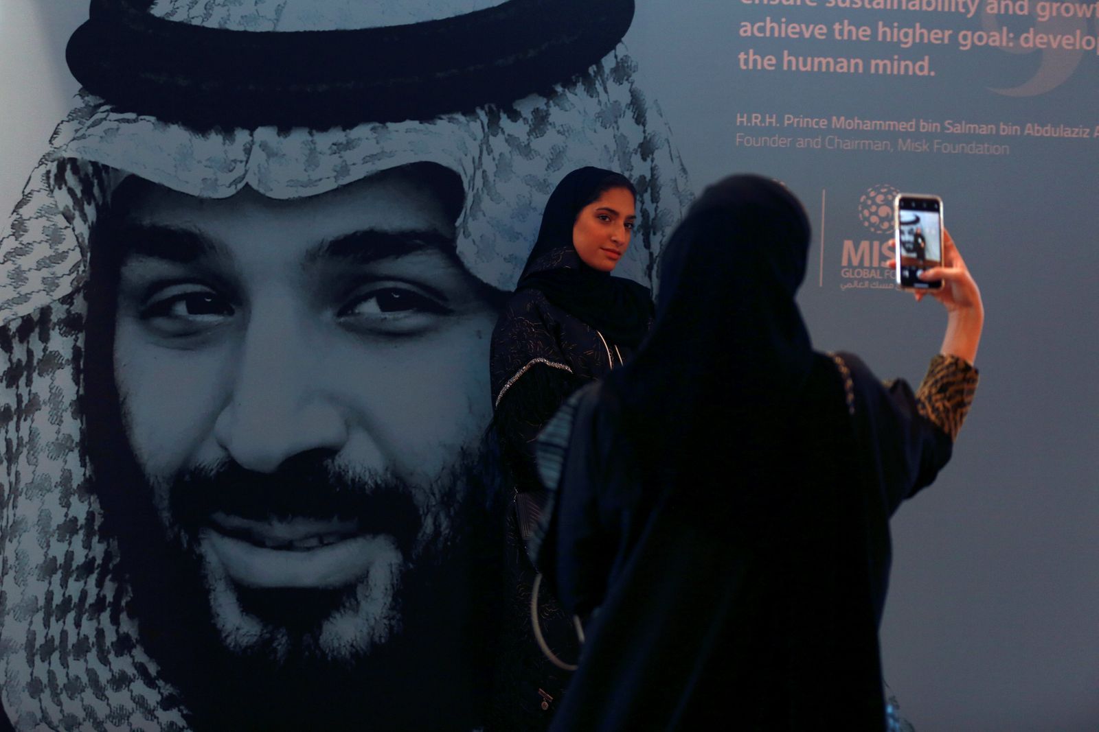 Ženy se fotí před plakátem s tváří saúdského korunního prince Muhammada bin Salmána.