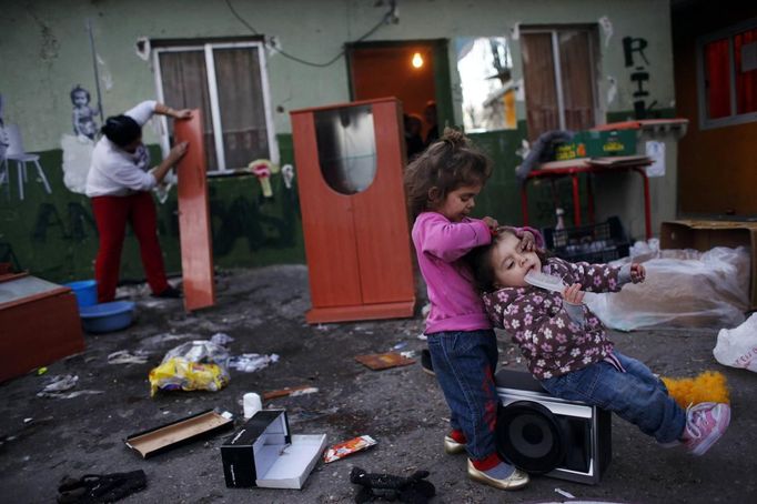 Nazareth Duval (L) combs her cousin Yasmin's hair as their aunt Rosa Gabarri cleans the furniture which she is removing from her parents' home a day before its demolition at the Spanish gypsy settlement of Puerta de Hierro outside Madrid February 14, 2012. Fifty-four families have been living in Puerta de Hierro, on the banks of the Manzanares river for over 50 years. Since the summer of 2010, the community has been subject to evictions on the grounds that the dwellings are illegal. Families whose houses have been demolished, move in with relatives whose houses still remain while the debris keeps piling up around them as more demolitions take place. Picture taken February 14, 2012. REUTERS/Susana Vera (SPAIN - Tags: SOCIETY) ATTENTION EDITORS - PICTURE 12 OF 31 FOR PACKAGE 'GYPSY SITE DEMOLISHED' SEARCH 'GYPSY SITE' FOR ALL IMAGES Published: Lis. 5, 2012, 4:11 odp.