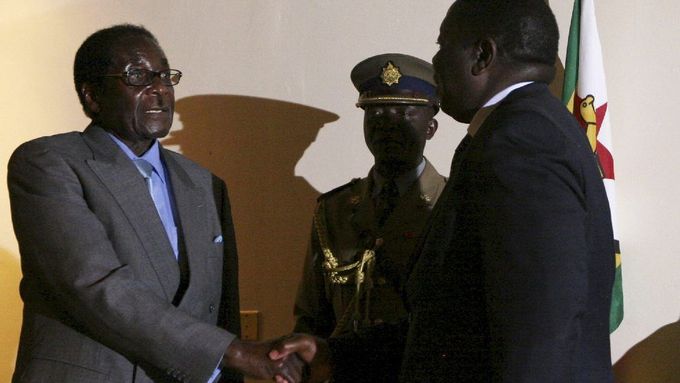 Historický okamžik: dva nesmiřitelní rivalové - prezident Robert Mugabe a opoziční vůdce Morgan Tsvangirai - si podávají ruku po podpisu rámcové dohody o zahájení dialogu