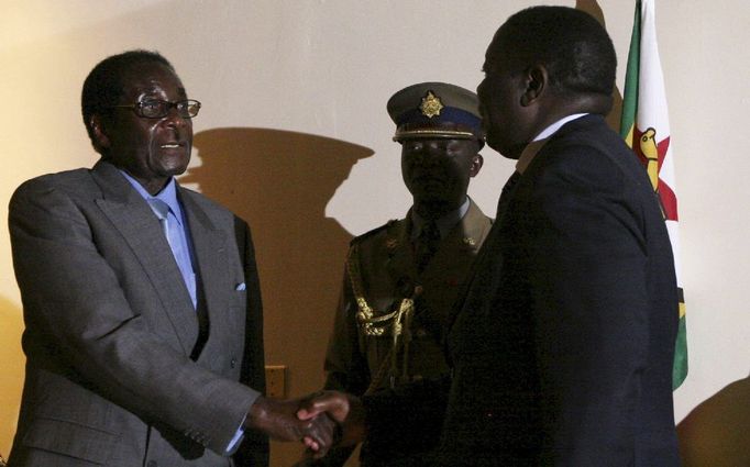 Historický okamžik: dva nesmiřitelní rivalové - prezident Robert Mugabe a opoziční vůdce Morgan Tsvangirai - si podávají ruku po podpisu rámcové dohody o zahájení dialogu