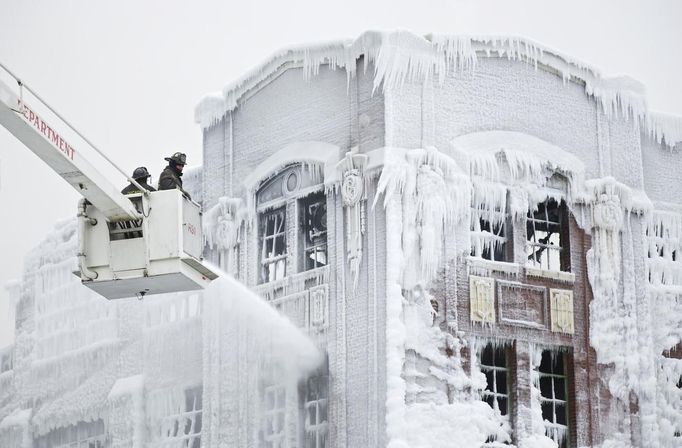 Firefighters spray down hot spots on an ice covered warehouse that caught fire Tuesday night in Chicago January 23, 2013. Fire department officials said it is the biggest fire the department has had to battle in years and one-third of all Chicago firefighters were on the scene at one point or another trying to put out the flames. An Arctic blast continues to gripped the U.S. Midwest and Northeast Wednesday, with at least three deaths linked to the frigid weather, and fierce winds made some locations feel as cold as 50 degrees below zero Fahrenheit. (minus 46 degrees Celsius) REUTERS/John Gress (UNITED STATES - Tags: DISASTER ENVIRONMENT) Published: Led. 23, 2013, 4:31 odp.