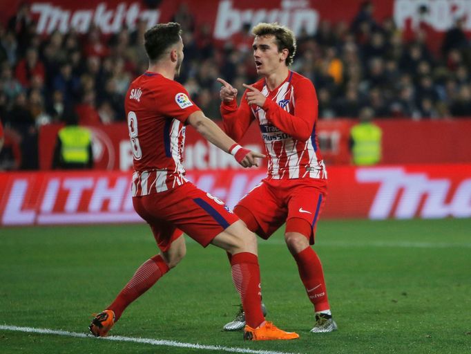 Saúl Ňíguez a Antoine Griezmann slaví gól Atlética na hřišti Sevilly v 25. kole španělské ligy.