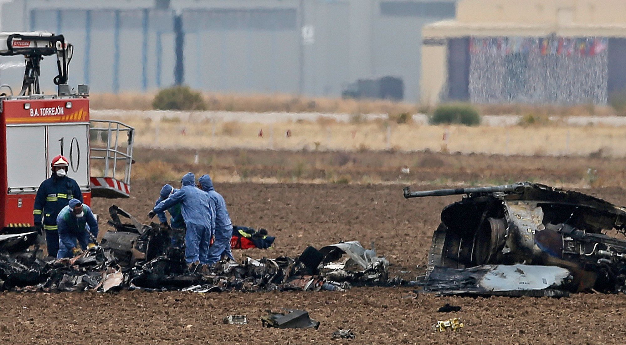 Španělští záchranáři odklízejí trosky ze zřícené stíhačky F-18.