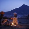 Camel herders warm themselves by a fire at Pushkar Fair in the desert Indian state of Rajasthan November 23, 2012. Many international and domestic tourists throng to Pushkar to witness one of the most colourful and popular fairs in India. Thousands of animals, mainly camels, are brought to the fair to be sold and traded. REUTERS/Danish Siddiqui (INDIA - Tags: SOCIETY ANIMALS) Published: Lis. 23, 2012, 5:23 odp.