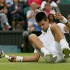 Srbský tenista Novak Djokovič při pádu v semifinálovém utkání Wimbledonu 2012 se Švýcarem Rogerem Federerem.