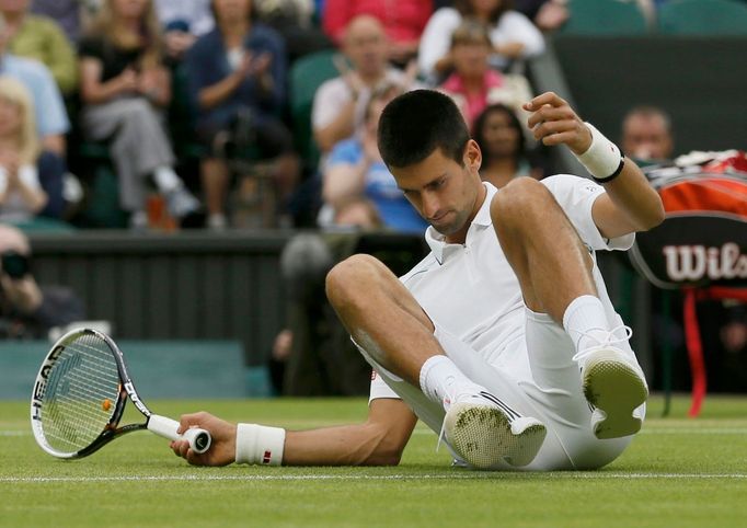 Srbský tenista Novak Djokovič při pádu v semifinálovém utkání Wimbledonu 2012 se Švýcarem Rogerem Federerem.