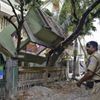 Indian security personnel stands near a collapsed house after an earthquake in Siliguri