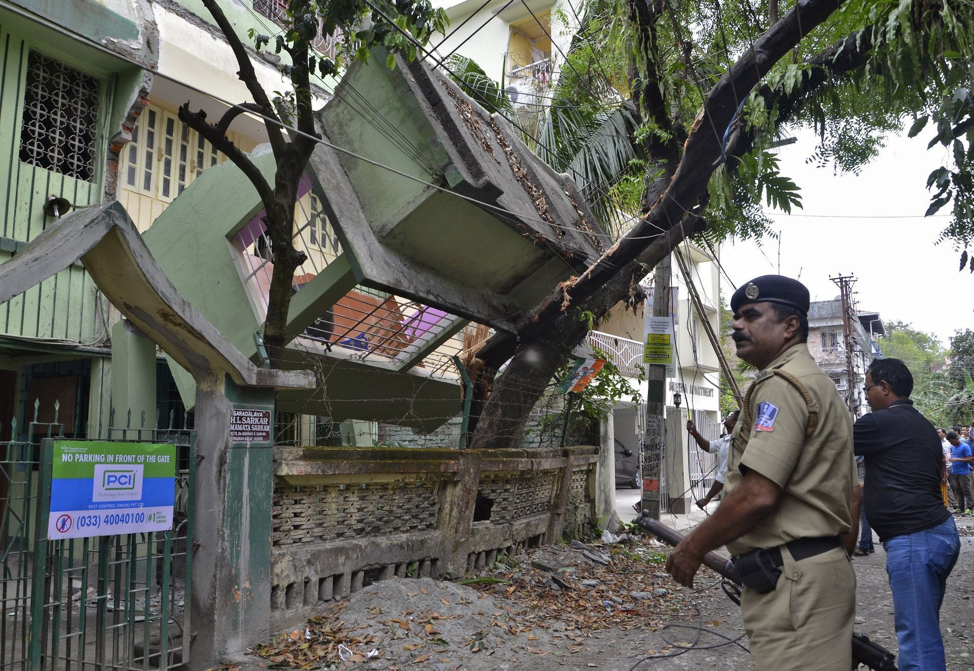 Indian security personnel stands near a collapsed house after an earthquake in Siliguri