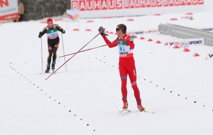 Norský finišman Petter Northug se ohlíží. V cílové rovince nedal Němci Axelu Teichmannovi nejmenší šanci.