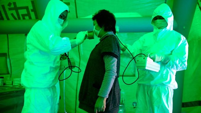 Žena, evakuovaná z nebezpečného dvacetikilometrového pásma kolem kolabující jaderné elektrárny Fukušima, při testování na přítomnost radioaktivity.