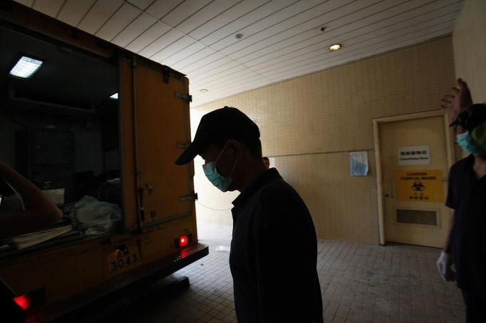 Mortuary workers prepare to unload bodies of ferry passengers who died in an accident in Hong Kong October 2, 2012. At least 36 people died and dozens were injured when a ferry carrying more than 120 people on a company outing collided with another ferry and sank near an island south of Hong Kong on Monday night in one of the city's worst maritime accidents. REUTERS/Bobby Yip (CHINA - Tags: DISASTER TRANSPORT) Published: Říj. 2, 2012, 3:37 dop.